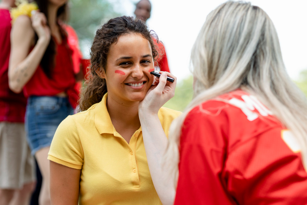 Une femme se fait maquiller par une autre femme lors d'un festival.
